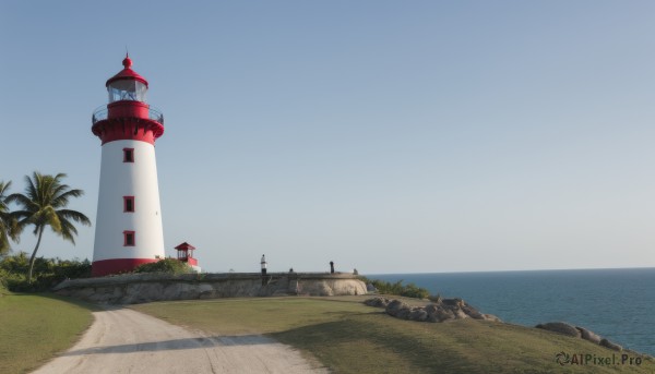 outdoors,sky,day,water,tree,blue sky,no humans,ocean,beach,grass,building,scenery,sand,palm tree,horizon,road,castle,tower,shore,rock,bush,lighthouse