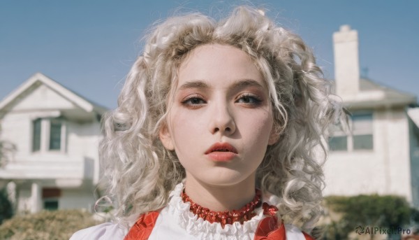 1girl,solo,long hair,looking at viewer,blue eyes,blonde hair,jewelry,white shirt,outdoors,parted lips,sky,day,necklace,blurry,black eyes,blue sky,lips,makeup,depth of field,blurry background,wavy hair,building,messy hair,portrait,forehead,freckles,curly hair,realistic,red lips,pearl necklace,shirt,frills,teeth,grey eyes,house