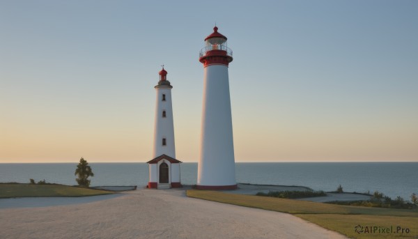 outdoors,sky,water,tree,blue sky,no humans,ocean,grass,building,scenery,horizon,road,house,castle,tower,day,beach,nature,sunset,sand,lighthouse