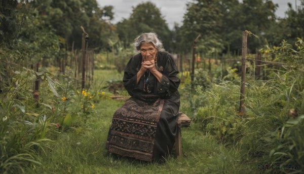 1girl,solo,looking at viewer,short hair,long sleeves,1boy,dress,jewelry,sitting,closed mouth,closed eyes,flower,white hair,grey hair,male focus,outdoors,day,necklace,blurry,black dress,tree,depth of field,blurry background,own hands together,grass,plant,nature,beads,robe,fence,field,old,old man,suitcase,praying,old woman,bracelet,ring,smoking