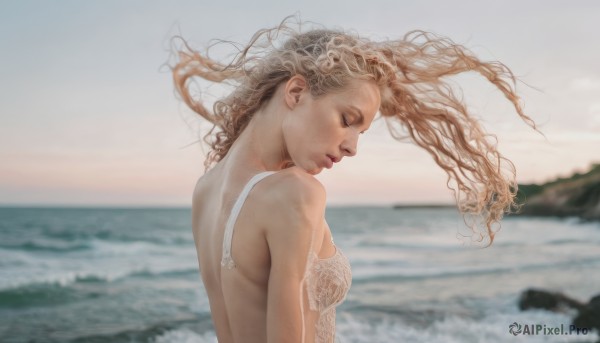 1girl,solo,long hair,breasts,blonde hair,brown hair,dress,bare shoulders,underwear,closed eyes,upper body,small breasts,outdoors,sky,day,water,bra,white dress,blurry,from side,lips,profile,floating hair,depth of field,blurry background,ocean,wavy hair,beach,wind,white bra,curly hair,realistic,nose,closed mouth,looking down,waves