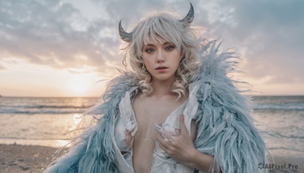 1girl,solo,long hair,breasts,looking at viewer,bangs,blue eyes,blonde hair,shirt,medium breasts,white shirt,upper body,white hair,outdoors,parted lips,open clothes,horns,sky,day,cloud,blurry,lips,torn clothes,depth of field,blurry background,ocean,beach,cloudy sky,feathers,breasts apart,curly hair,realistic,torn shirt,fingernails