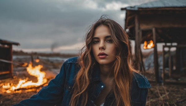 1girl,solo,long hair,breasts,looking at viewer,blonde hair,brown hair,cleavage,brown eyes,jacket,upper body,outdoors,parted lips,open clothes,sky,cloud,blurry,lips,dutch angle,depth of field,blurry background,fire,denim,blue jacket,building,freckles,realistic,leather,denim jacket,day,makeup,lipstick,leather jacket