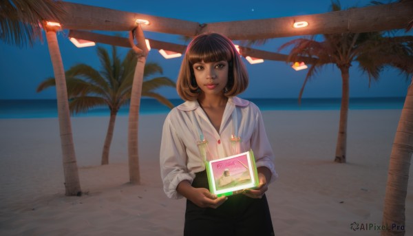 1girl,solo,looking at viewer,smile,short hair,bangs,skirt,brown hair,shirt,long sleeves,holding,brown eyes,standing,white shirt,cowboy shot,outdoors,parted lips,sky,day,dark skin,blunt bangs,medium hair,water,dark-skinned female,tree,blue sky,lips,makeup,night,glowing,ocean,beach,night sky,nose,sand,palm tree,horizon,black hair,hood,black skirt,hoodie,bob cut,hood down,lipstick,scenery,realistic,handheld game console,sleeves pushed up,desert