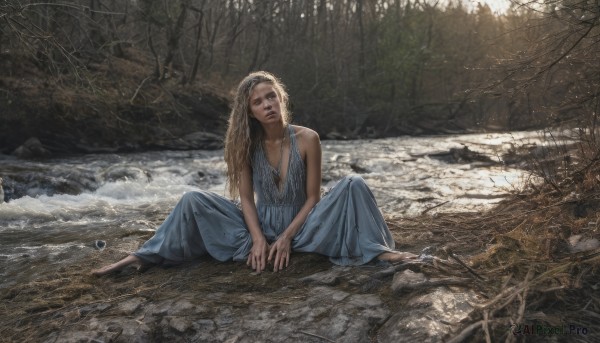 1girl,solo,long hair,looking at viewer,blonde hair,dress,bare shoulders,sitting,outdoors,barefoot,sleeveless,spread legs,water,necklace,white dress,tree,sleeveless dress,blue dress,nature,rock,realistic,on ground,dirty,dirty feet,blue eyes,jewelry,closed mouth,collarbone,full body,parted lips,day,flat chest,lips,head tilt,bare arms,sunlight,scenery,forest,long dress,stream