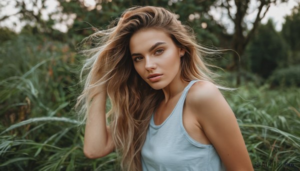 1girl,solo,long hair,breasts,looking at viewer,brown hair,shirt,bare shoulders,brown eyes,jewelry,upper body,earrings,small breasts,outdoors,sleeveless,mole,blurry,lips,depth of field,blurry background,tank top,grass,wind,freckles,hand in own hair,realistic,nose,stud earrings,white tank top,day,plant,nature