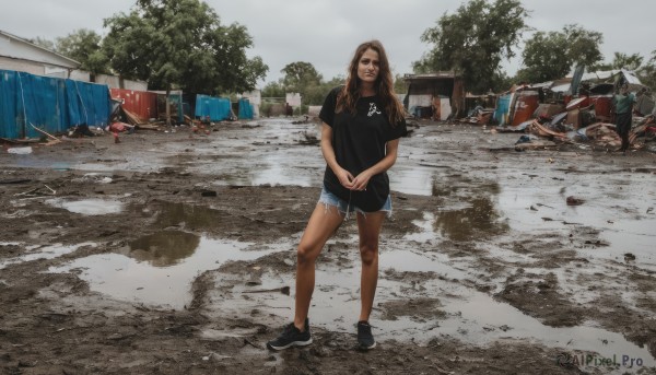 1girl,solo,long hair,looking at viewer,brown hair,shirt,standing,full body,short sleeves,outdoors,shoes,shorts,day,black footwear,tree,torn clothes,black shirt,short shorts,own hands together,denim,t-shirt,sneakers,blue shorts,denim shorts,realistic,cutoffs,photo background,smile,closed mouth,sky,solo focus,bare legs,facial hair,building,scenery