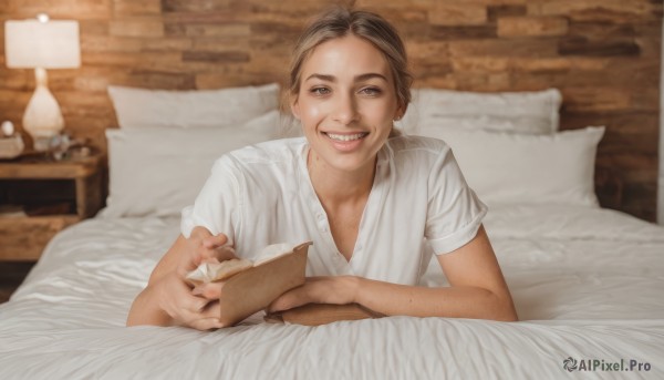 1girl,solo,looking at viewer,smile,short hair,brown hair,shirt,1boy,holding,brown eyes,white shirt,upper body,short sleeves,male focus,lying,teeth,tongue,indoors,tongue out,grin,blurry,fingernails,pillow,book,bed,depth of field,blurry background,bed sheet,on bed,child,freckles,holding book,open book,realistic,reading,lamp,open mouth,food,stuffed toy,hospital bed