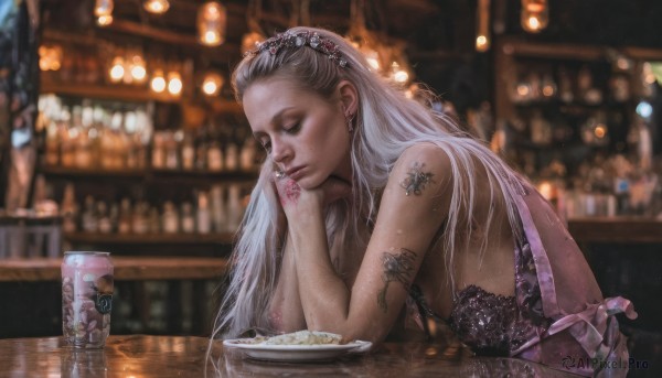 1girl,solo,long hair,breasts,hair ornament,dress,bare shoulders,jewelry,sitting,closed eyes,upper body,white hair,grey hair,earrings,food,indoors,mole,blurry,black dress,cup,lips,eyelashes,strapless,tattoo,makeup,depth of field,blurry background,piercing,table,ring,bottle,tiara,alcohol,drinking glass,freckles,head rest,backless outfit,realistic,nose,arm tattoo,wine glass,beer,elbow rest,bar (place),counter,cleavage,medium breasts,nipples,plate