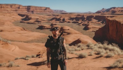 solo,short hair,brown hair,shirt,1boy,standing,weapon,male focus,outdoors,sky,day,belt,pants,uniform,vest,blue sky,gun,military,goggles,scenery,rifle,goggles on head,mountain,sand,assault rifle,desert,dust,hat,realistic