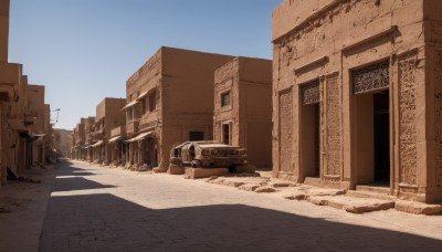 outdoors,sky,day,tree,blue sky,no humans,window,shadow,ground vehicle,building,scenery,motor vehicle,city,car,road,ruins,street,desert,lamppost