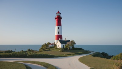 outdoors,sky,day,water,tree,blue sky,no humans,ocean,grass,building,nature,scenery,horizon,road,bush,lamppost,river,castle,tower,landscape,path,beach,sand,shore,lighthouse