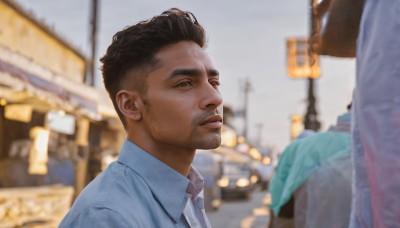 solo,short hair,brown hair,shirt,black hair,1boy,brown eyes,white shirt,upper body,male focus,outdoors,multiple boys,solo focus,collared shirt,blurry,depth of field,blurry background,facial hair,building,beard,realistic,nose,stubble,jewelry,closed mouth,day,lips,dress shirt,blue shirt,photo background