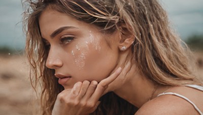 1girl,solo,long hair,looking at viewer,blonde hair,brown hair,brown eyes,jewelry,earrings,outdoors,day,hand up,mole,blurry,from side,lips,wet,grey eyes,eyelashes,depth of field,blurry background,portrait,close-up,freckles,realistic,nose,bare shoulders,necklace,profile,wavy hair,looking away,messy hair,hand on own chin