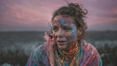 1girl,solo,looking at viewer,smile,brown hair,black hair,brown eyes,jewelry,upper body,outdoors,parted lips,sky,dark skin,necklace,hair bun,blurry,lips,blurry background,single hair bun,messy hair,portrait,realistic,dirty,dirty face,old woman,short hair,green eyes,cloud,dark-skinned female,looking to the side,facepaint,looking afar