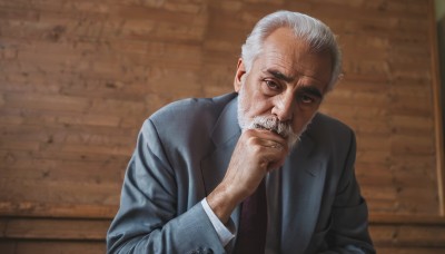 solo,looking at viewer,shirt,long sleeves,1boy,closed mouth,jacket,upper body,white hair,grey hair,male focus,necktie,indoors,hand up,blurry,black eyes,blurry background,facial hair,formal,suit,blue jacket,red necktie,beard,realistic,grey jacket,mustache,hand on own chin,manly,old,old man,wrinkled skin,white shirt,collared shirt,black jacket,grey eyes,parody,black necktie,brick wall