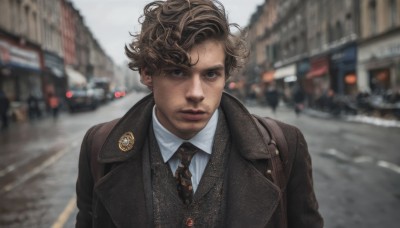 solo,looking at viewer,short hair,brown hair,shirt,1boy,brown eyes,closed mouth,jacket,white shirt,upper body,male focus,outdoors,necktie,day,collared shirt,blurry,black eyes,vest,lips,coat,black jacket,blurry background,facial hair,ground vehicle,black necktie,motor vehicle,freckles,curly hair,brown jacket,realistic,car,road,badge,street,photo background,brown necktie,open clothes,bag,depth of field,wing collar,building,black vest,city,stubble