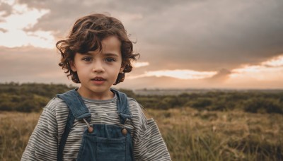 1girl,solo,looking at viewer,short hair,blue eyes,brown hair,shirt,long sleeves,brown eyes,upper body,outdoors,parted lips,sky,day,striped,cloud,blurry,lips,depth of field,blurry background,cloudy sky,child,curly hair,striped shirt,realistic,overalls,field,open mouth,teeth,grass,denim,wind,sunset