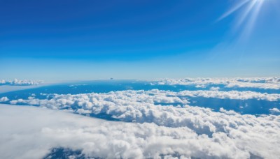 monochrome,outdoors,sky,day,cloud,water,tree,blue sky,no humans,bird,ocean,beach,sunlight,nature,scenery,blue theme,mountain,sun,horizon,landscape,shore,above clouds,light rays