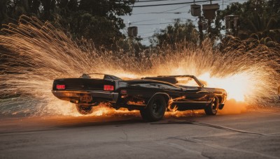 outdoors,sky,tree,no humans,ground vehicle,nature,scenery,motor vehicle,realistic,car,road,explosion,vehicle focus,power lines,utility pole,sports car,truck,fire,sunset,photo background,burning