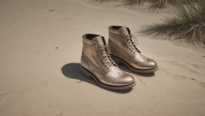 boots,outdoors,shoes,no humans,shadow,brown footwear,grass,sneakers,cross-laced footwear,sand,brown theme,still life,shoelaces,plant