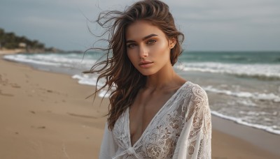 1girl,solo,long hair,breasts,looking at viewer,brown hair,long sleeves,dress,cleavage,brown eyes,closed mouth,collarbone,upper body,small breasts,outdoors,parted lips,day,water,white dress,blurry,lips,depth of field,blurry background,ocean,beach,wind,messy hair,realistic,nose,sand,plunging neckline,blue eyes,medium breasts,sky,see-through,thick eyebrows,waves,shore