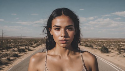 1girl,solo,long hair,looking at viewer,black hair,bare shoulders,brown eyes,collarbone,swimsuit,upper body,bikini,outdoors,parted lips,sky,day,cloud,mole,blurry,lips,mole under eye,freckles,realistic,nose,road,photo background,breasts,cleavage,bra,blue sky,messy hair,portrait,desert