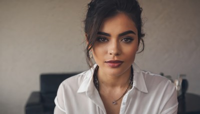 1girl,solo,looking at viewer,short hair,shirt,black hair,jewelry,sitting,white shirt,upper body,earrings,parted lips,collared shirt,indoors,necklace,blurry,black eyes,lips,grey eyes,dress shirt,blurry background,chair,thick eyebrows,messy hair,portrait,freckles,realistic,nose,brown eyes,makeup,lipstick,close-up