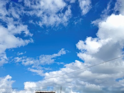 outdoors,sky,day,cloud,blue sky,no humans,cloudy sky,building,scenery,blue theme,fence,railing,power lines,utility pole,cumulonimbus cloud,railroad tracks