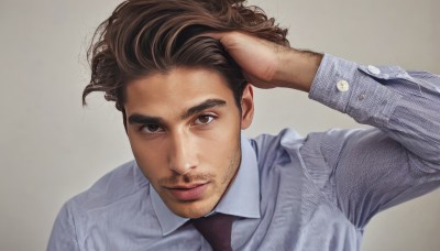 solo,looking at viewer,short hair,simple background,brown hair,shirt,long sleeves,1boy,brown eyes,closed mouth,white shirt,upper body,male focus,necktie,collared shirt,grey background,arm up,lips,facial hair,grey shirt,hand in own hair,realistic,mustache,stubble,hand on own head,dress shirt,portrait,beard,watch