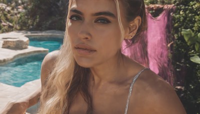 1girl,solo,long hair,looking at viewer,blue eyes,blonde hair,brown hair,jewelry,closed mouth,collarbone,upper body,earrings,outdoors,day,dark skin,water,blurry,dark-skinned female,lips,wet,thick eyebrows,towel,portrait,realistic,nose,pool,bare shoulders,brown eyes,blurry background,nature