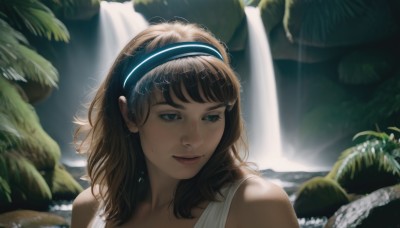 1girl,solo,long hair,smile,bangs,blue eyes,brown hair,bare shoulders,upper body,hairband,outdoors,water,mole,blurry,lips,looking away,sunlight,plant,portrait,rock,realistic,waterfall,jewelry,closed mouth,day,looking to the side,eyelashes,depth of field,blurry background,leaf,tank top,nature,backlighting,freckles,nose