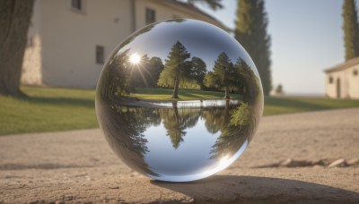 outdoors,sky,day,water,blurry,tree,blue sky,no humans,window,depth of field,blurry background,sunlight,grass,building,scenery,reflection,sun,road,bush,house,cloud,nature,ball