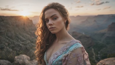 1girl,solo,long hair,breasts,looking at viewer,blue eyes,brown hair,cleavage,jewelry,medium breasts,closed mouth,upper body,earrings,outdoors,sky,day,cloud,mole,blurry,lips,blurry background,wavy hair,sunlight,mole under mouth,freckles,curly hair,sunset,mole on breast,mountain,realistic,nose,mole on neck,mole on cheek,brown eyes,collarbone,depth of field,thick eyebrows,cloudy sky,scenery,backlighting,rock,sun,mole on body