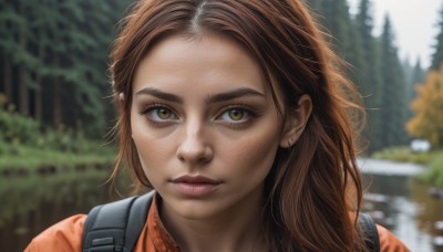 1girl,solo,long hair,looking at viewer,brown hair,shirt,brown eyes,jewelry,closed mouth,earrings,outdoors,day,bag,blurry,tree,lips,eyelashes,depth of field,blurry background,piercing,backpack,portrait,forehead,freckles,realistic,nose,stud earrings,orange shirt,close-up