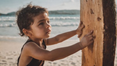 solo,short hair,brown hair,black hair,1boy,brown eyes,closed mouth,upper body,male focus,outdoors,sleeveless,day,dark skin,water,blurry,lips,depth of field,blurry background,ocean,beach,tank top,messy hair,child,curly hair,realistic,nose,sand,male child,holding,sky,aged down,dirty,shore,dirty face