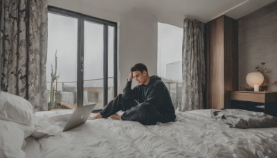 solo,short hair,black hair,long sleeves,1boy,sitting,male focus,barefoot,pants,indoors,hood,pillow,window,bed,hoodie,facial hair,on bed,black pants,hood down,plant,curtains,scenery,lamp,computer,hand on own head,very short hair,bedroom,black hoodie,wide shot,laptop,buzz cut,looking at viewer,closed mouth,full body,phone,building,sideburns,realistic,stubble,carpet