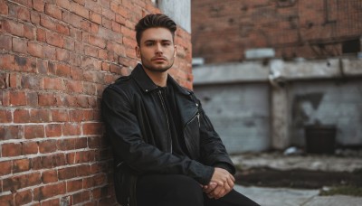 solo,looking at viewer,short hair,brown hair,shirt,black hair,long sleeves,1boy,brown eyes,sitting,closed mouth,jacket,male focus,outdoors,open clothes,pants,blurry,open jacket,black jacket,black shirt,facial hair,black pants,own hands together,beard,realistic,stubble,wall,leather,undercut,brick wall,leather jacket,photo background,day,collared shirt,blurry background,zipper,hands on lap