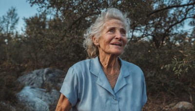 solo,smile,open mouth,shirt,1boy,jewelry,upper body,white hair,short sleeves,grey hair,male focus,earrings,outdoors,parted lips,teeth,day,collared shirt,blurry,tree,blurry background,facial hair,blue shirt,rock,realistic,old,old man,photo background,old woman,wrinkled skin,1girl,looking at viewer,blue eyes,blonde hair