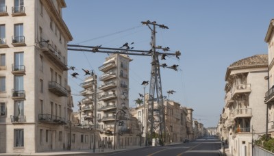 outdoors,sky,day,tree,blue sky,no humans,window,bird,ground vehicle,building,scenery,motor vehicle,city,sign,road,cityscape,house,power lines,lamppost,street,utility pole,town,balcony,crosswalk,real world location,flying,car,traffic light,vanishing point