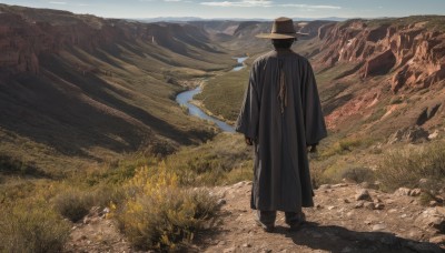 solo,black hair,long sleeves,1boy,hat,standing,male focus,outdoors,sky,day,cloud,from behind,coat,shadow,grass,scenery,smoke,rock,mountain,brown headwear,facing away,field,gloves,black gloves,black footwear,blue sky,cloak