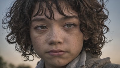 1girl,solo,looking at viewer,short hair,brown hair,brown eyes,closed mouth,outdoors,sky,blurry,lips,depth of field,blurry background,expressionless,messy hair,portrait,freckles,curly hair,realistic,nose,bangs,black hair,wind,close-up