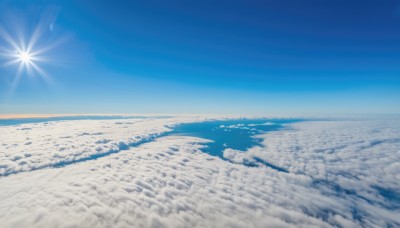 monochrome,outdoors,sky,day,cloud,blue sky,no humans,ocean,scenery,blue theme,mountain,sun,horizon,landscape,above clouds,water,beach,sunlight,snow,lens flare