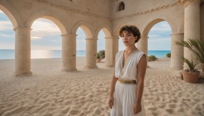 1girl,solo,looking at viewer,short hair,brown hair,1boy,dress,brown eyes,closed mouth,standing,outdoors,sky,sleeveless,day,cloud,dark skin,water,white dress,dark-skinned female,blue sky,lips,ocean,beach,plant,scenery,androgynous,robe,arms at sides,horizon,potted plant,pillar,tunic,arch,column,greek clothes,smile,male focus,parted lips,bare arms,curly hair,sand