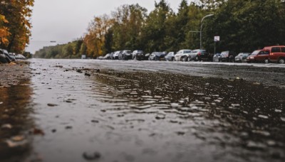 outdoors,sky,day,water,tree,no humans,ground vehicle,nature,scenery,motor vehicle,reflection,realistic,car,road,vehicle focus,lamppost,river,photo background,grey sky,real world location,snow,rock,road sign