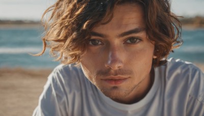 solo,looking at viewer,short hair,brown hair,shirt,1boy,brown eyes,closed mouth,white shirt,upper body,male focus,outdoors,day,water,blurry,lips,blurry background,facial hair,ocean,scar,beach,portrait,beard,freckles,realistic,mustache,sand,stubble,depth of field,wind,t-shirt,nose,shore