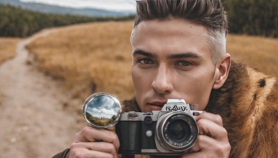 solo,looking at viewer,short hair,brown hair,black hair,1boy,holding,brown eyes,closed mouth,male focus,multicolored hair,outdoors,day,blurry,two-tone hair,fur trim,blurry background,portrait,realistic,camera,photo background,holding camera,coat,facial hair,close-up