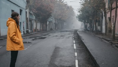 1girl,solo,long hair,brown hair,black hair,long sleeves,standing,jacket,outdoors,day,pants,hood,from side,tree,coat,hoodie,profile,mask,black pants,hood down,ground vehicle,building,scenery,hooded jacket,motor vehicle,city,sign,hands in pockets,mouth mask,road,autumn leaves,power lines,lamppost,street,utility pole,sidewalk,sky,walking,realistic,yellow jacket,crosswalk,vanishing point