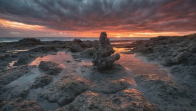 outdoors,sky,cloud,water,no humans,ocean,cloudy sky,scenery,sunset,rock,mountain,horizon,landscape,mountainous horizon,orange sky,cliff,red sky,solo,sitting,beach,sand,shore