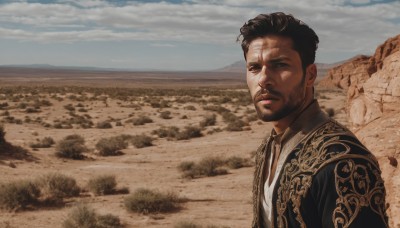 solo,looking at viewer,short hair,brown hair,shirt,black hair,1boy,closed mouth,jacket,white shirt,upper body,male focus,outdoors,sky,day,collared shirt,cloud,facial hair,scenery,beard,realistic,mustache,field,desert,brown eyes,open clothes,dark skin,blue sky,black jacket,looking to the side,dark-skinned male,cloudy sky,rock,sand